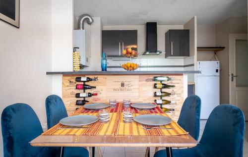 - une table en bois entourée de chaises bleues dans la cuisine dans l'établissement Le Jardin des Consuls - T3 - Parking - Balcon orienté sud, à Montpellier