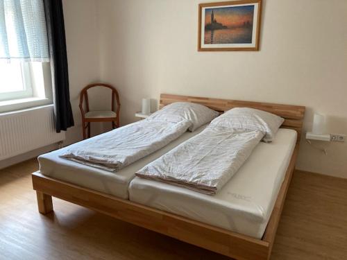 a bed in a bedroom with a wooden head board at Kleine Herberge in Strodehne