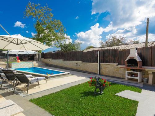 a swimming pool with a table and chairs and an umbrella at Villa Patrick-Luxury stone house in the center of Istria in Pazin