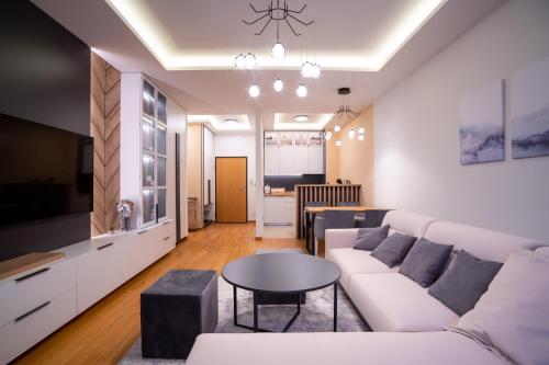 a living room with a white couch and a table at Apartman G8 Deluxe in Pale