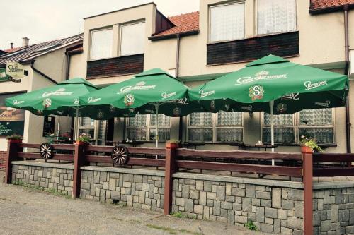 Hřiměždice的住宿－Penzion a restaurace U jezírka，一群绿色的伞坐在围栏上