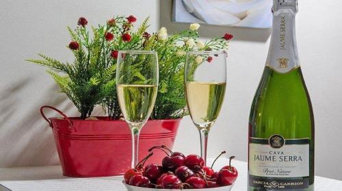 two glasses of champagne next to a bottle of wine and cherries at סוויטות דה בלנקה in Had Nes