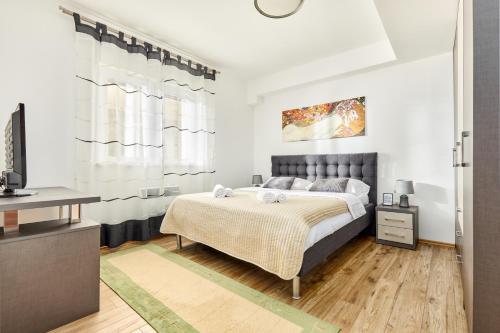 una camera con un letto e una televisione di Dimitris Apartments a Tivat