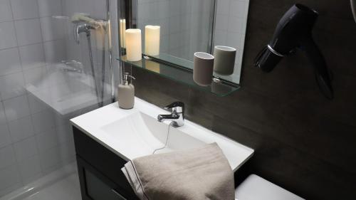 a bathroom with a white sink and a mirror at NEUF & MODERNE 35m2 - 100 mètres des pistes de ski in Pas de la Casa