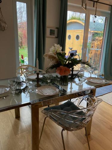 uma mesa de jantar com um vaso de flores em Ferienhaus Elisenhuus em Tönning