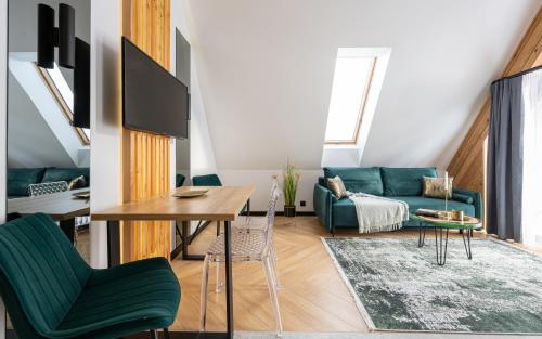 a living room with a green couch and a table at Wrota Chałubińskiego in Zakopane