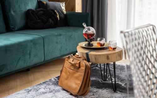 a living room with a couch and a table with a wine glass at Wrota Chałubińskiego in Zakopane