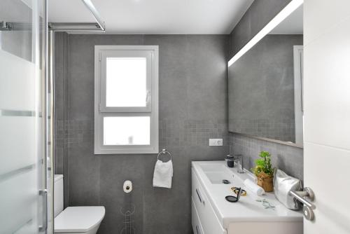 a bathroom with a sink and a toilet and a window at Apartment Nueva Suecia CR715 by VillaGranCanaria in San Agustin