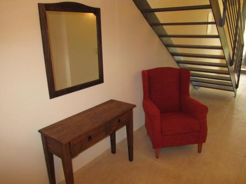 a red chair and a table and a mirror at Cal Metge de Gualba in gualba de Dalt