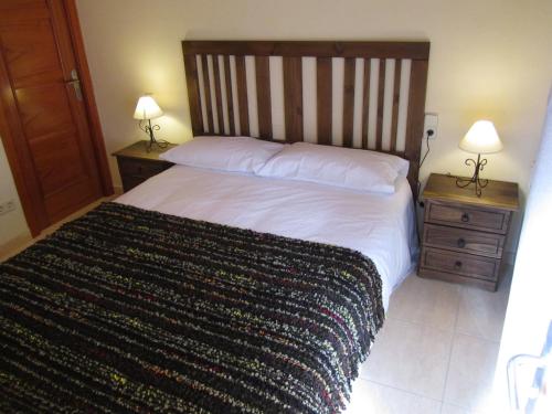 a bedroom with a large bed and two night stands at Cal Metge de Gualba in gualba de Dalt