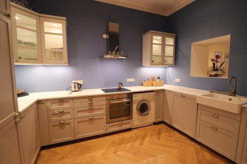 a kitchen with white cabinets and a washer and dryer at Wohnung mit Balkon beim Schloss Belvedere in Vienna