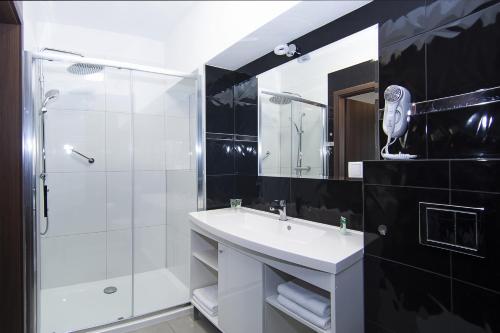 a bathroom with a white sink and a shower at InterHotel in Wrocław