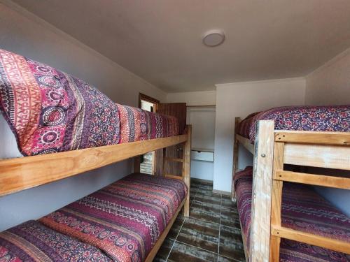 1 dormitorio con 2 literas en una habitación en Cabañas Olas del Bosque, en Pichilemu