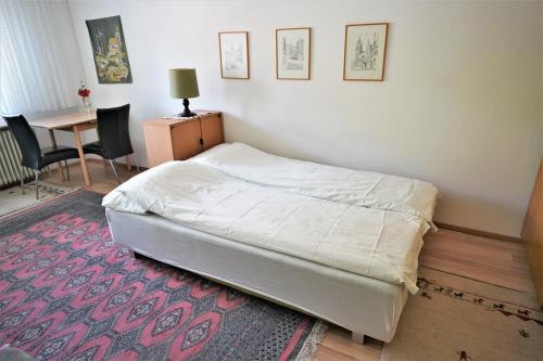ザールバッハ・ヒンターグレムにあるAppartement Petitのテーブルと椅子付きのベッドルームのベッド1台