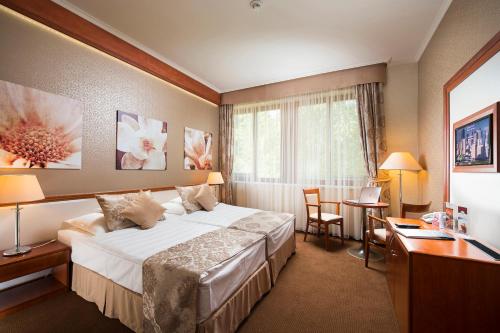 a hotel room with a bed and a desk at Aventinus Hotel in Nyíregyháza