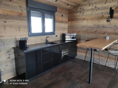 a kitchen with a sink and a wooden wall at Chalet neuf avec jacuzzi privé, vue imprenable sur Massif des Vosges in Belfahy
