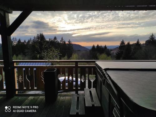 a deck with a view of a body of water at Chalet neuf avec jacuzzi privé, vue imprenable sur Massif des Vosges in Belfahy