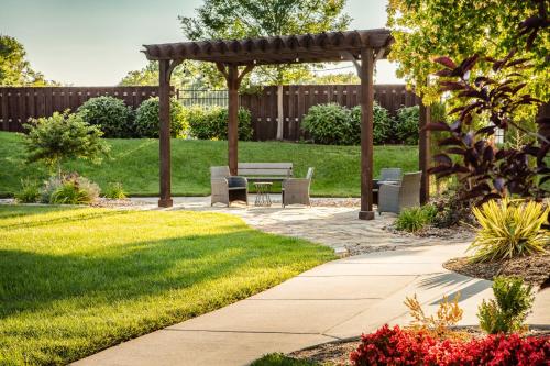 a garden with a bench and a pergola at Holiday Inn Wichita East I-35 by IHG in Wichita