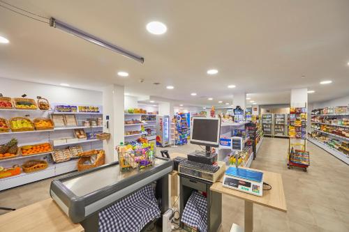 a grocery store aisle with a computer on a counter at Aparthotel Ponent Mar in Palmanova