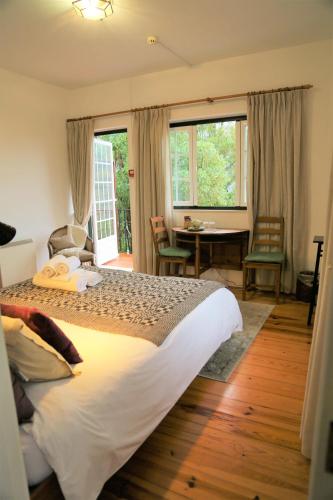 ein Schlafzimmer mit einem großen Bett, einem Tisch und Stühlen in der Unterkunft Casa do Valle in Sintra
