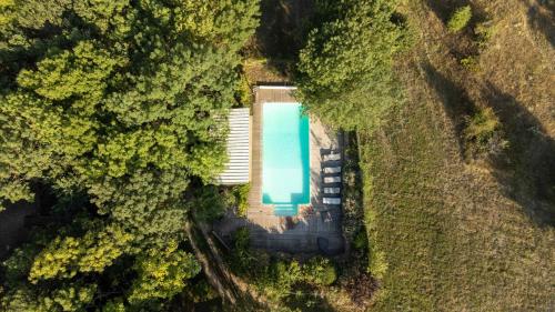 una vista aérea de una piscina en un bosque en Jacuzzi, sauna, healthy food dans ancienne bergerie en Roquetaillade