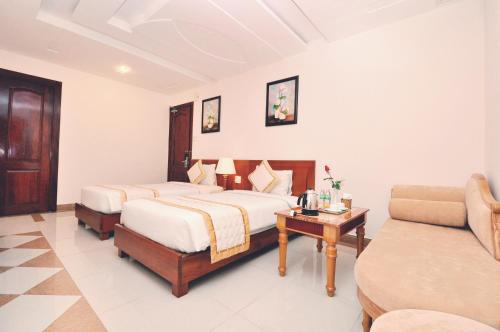 Una cama o camas en una habitación de Tan Hoang Long Hotel