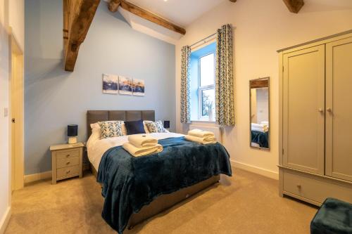 a bedroom with a bed and a window and a mirror at Clwyd Cottage - Two Bed, Barn Conversion with Private Hot Tub in Bodfari