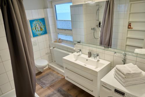 フレンスブルクにあるFerienwohnung KUSCHELNESTのバスルーム(洗面台、トイレ、鏡付)