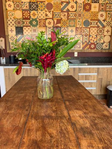 a vase of flowers sitting on a wooden table at House Flat Cacupé em Florianópolis in Florianópolis