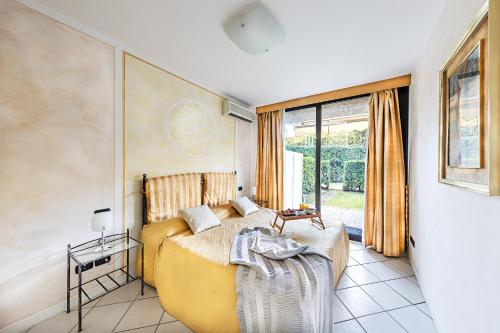 - une chambre avec un lit jaune et une fenêtre dans l'établissement Residence Villa Giulia 5-03 with pool by Wonderful Italy, à Desenzano del Garda