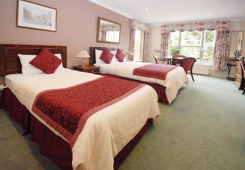 オックスフォードにあるMarlborough House - Guest Houseのベッド2台とデスクが備わるホテルルームです。