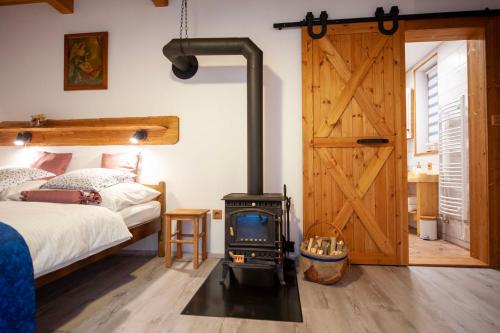 een slaapkamer met een houtkachel naast een bed bij Stodola Harrachov in Harrachov