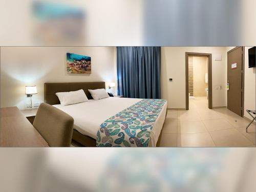 a hotel room with a bed and a chair at Hotel Kennedy Nova in Il-Gżira