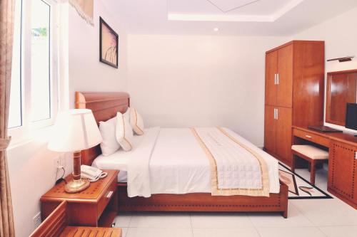 Una cama o camas en una habitación de Tan Hoang Long Hotel