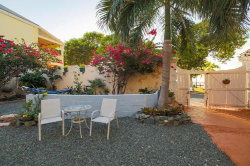 a patio with a table and chairs and a palm tree at Victoria House in Frederiksted