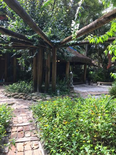 a garden with a wooden pergola and a pathway at Vila da Pousadinha in Ilha do Mel