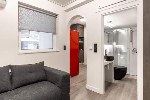 a living room with a couch and a red door at Brand-New , Delux apt in Central Athens! in Athens