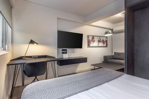 a bedroom with a desk and a bed and a desk with a monitor at Brand-New , Delux apt in Central Athens! in Athens