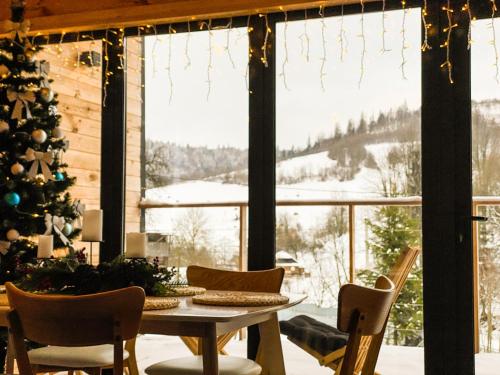a room with a christmas tree and a table and chairs at GUKHOUSE in Huklyvyy