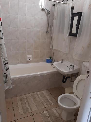 a bathroom with a tub and a toilet and a sink at Villa Mia Holiday Flats no 7 in St Lucia