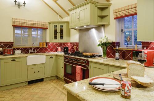 a kitchen with green cabinets and a stove top oven at Lavender Cottage in Thorndon