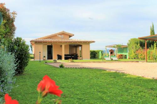 una casa con una flor roja en el patio en 2 bedrooms house with furnished terrace and wifi at Pescia Romana 3 km away from the beach, en Pescia Romana