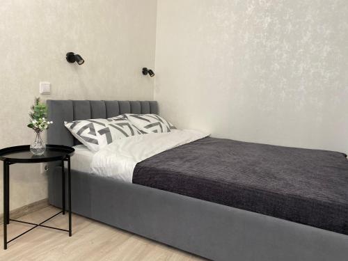 1 cama en un dormitorio con mesa auxiliar en SamaRA Apartments en Samara