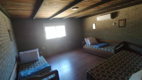 an empty room with two beds and a window at Casa en Jaureguiberry a 5 cuadras de la playa in Jaureguiberry