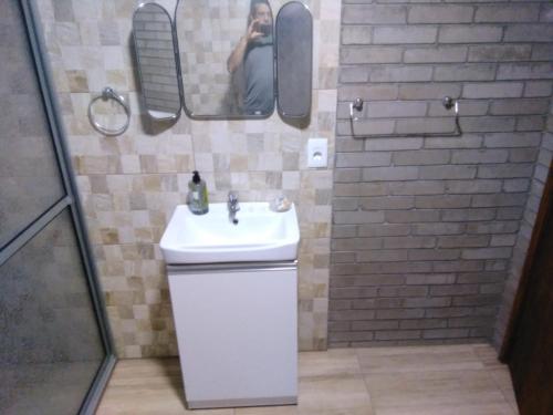 a person taking a picture of a bathroom with a sink at Casa en Jaureguiberry a 5 cuadras de la playa in Jaureguiberry
