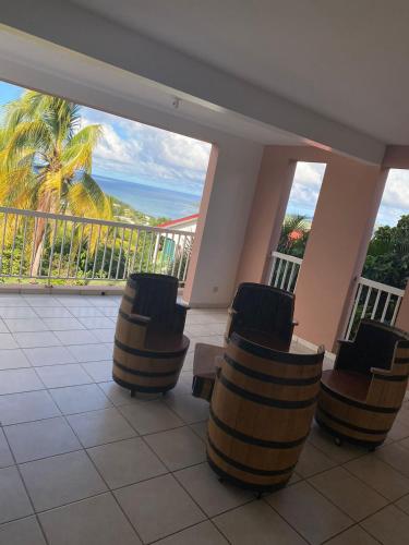 einen Balkon mit Stühlen und Meerblick in der Unterkunft Bas de villa , Résidence Venus calme, vue sur mer in La Trinité