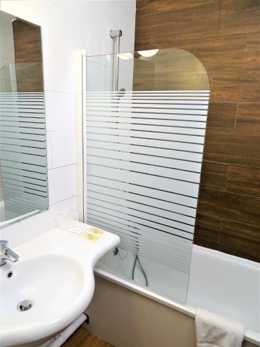 a bathroom with a sink and a glass window at Euro Hôtel Paris Créteil in Créteil