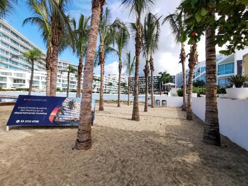 a row of palm trees on a sandy beach at Area Ocean De luxe sanitizado in Nuevo Vallarta