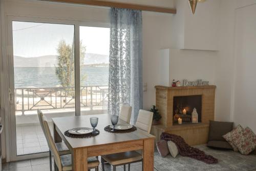 a dining room with a table and a fireplace at Seaside Apartments in Áyios Vasílios