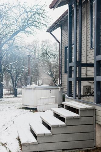 a porch of a house with snow on the ground at Farm hostel - The house in Elektrėnai
